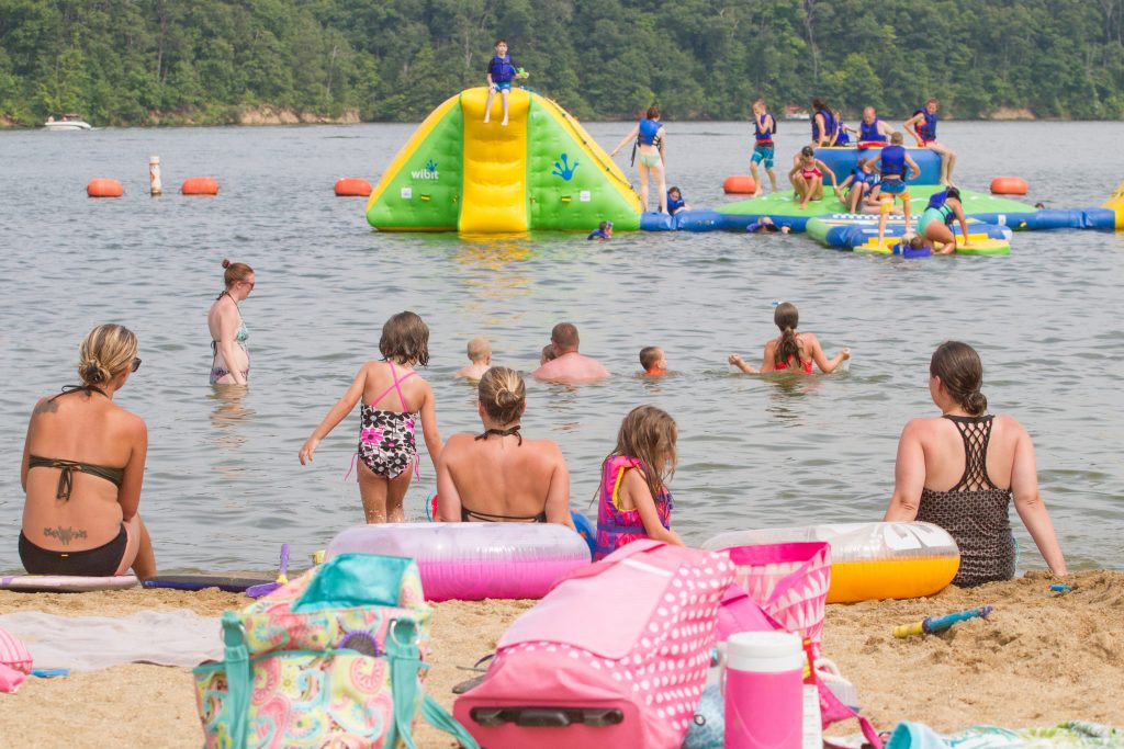 Moms watch their children in the water and on the aquatic playground.