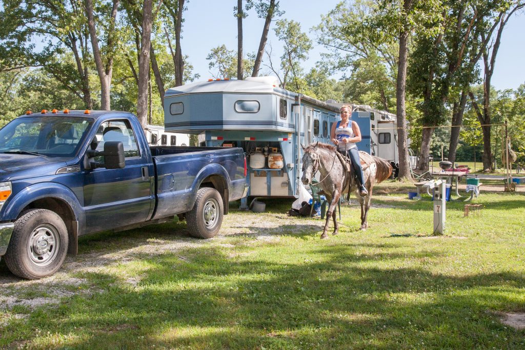 An equestrian campground site with a woman on a horse.